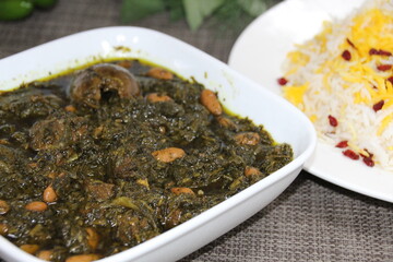 Ghormeh Sabzi or mixed vegetables served in a dish isolated on wooden background side view