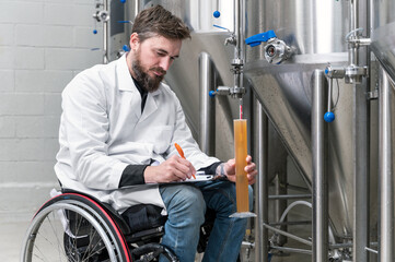 Person with disability who uses a wheelchair working at craft beer factory. High quality photography