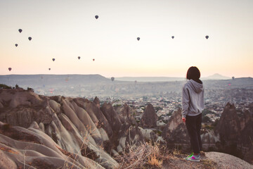Young brunette caucasian woman stand alone in scenic nature enjoy sunrise on vacation outdoors enjoy travel solo. Woman well-being adventure lifestyle