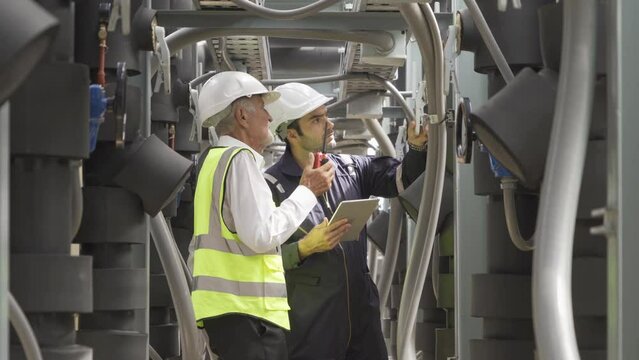 Engineer men or worker team, people working in industry factory. Chiller tower on rooftop building. System work machine. Condenser Water Supply pipe lines. Ventilation compressor