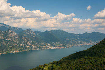 Obraz na płótnie Canvas Panorama at Lake Iseo and mountains around at sunny day with clouds. Bergamo, Lombardy, Italy.