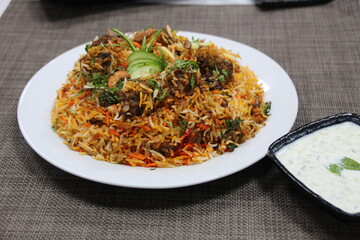 Kashmeri Lamb Biryani with raita served in a dish isolated on wooden background side view