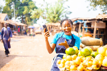 over excited African market woman using mobile phone
