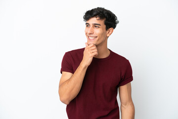 Young Argentinian man isolated on white background looking to the side and smiling