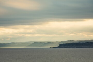 Beautiful water view with mountains and gray clouds in the background