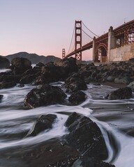 Low angle shot of Golden Gate Bridge in San Francisco, California from the shore in long exposure