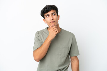 Fototapeta na wymiar Young Argentinian man isolated on white background having doubts