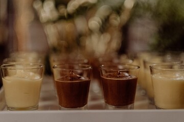 Row of chocolate and vanilla desserts in glasses with blurred background