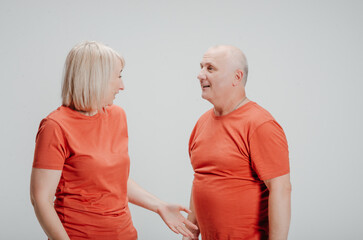 man and woman in orange t-shirts on a white background