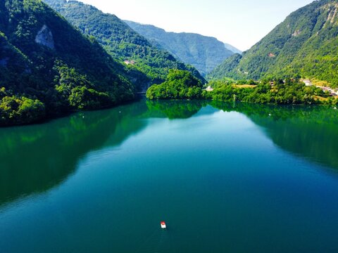 Scenic view of Lake Corlo (The Lake of Arsie) among forested mountains, Italy