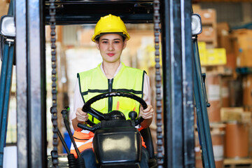 Young asian woman Warehouse staff driving forklift operator moving boxes in industrial container warehouse factory. Man worker woking with forklift.