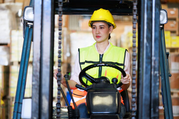 Young asian woman Warehouse staff driving forklift operator moving boxes in industrial container warehouse factory. Man worker woking with forklift.