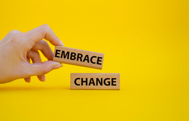 Embrace change symbol. Concept word Embrace change on wooden blocks. Beautiful yellow background. Businessman hand. Business and Embrace change concept. Copy space