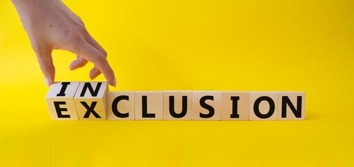 Inclusion and Exclusion symbol. Businessman hand. Turned wooden cubes with words Inclusion and...