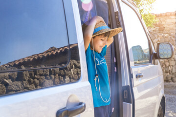 kid on a camper van door with straw hat © Komuso & Colorsandia