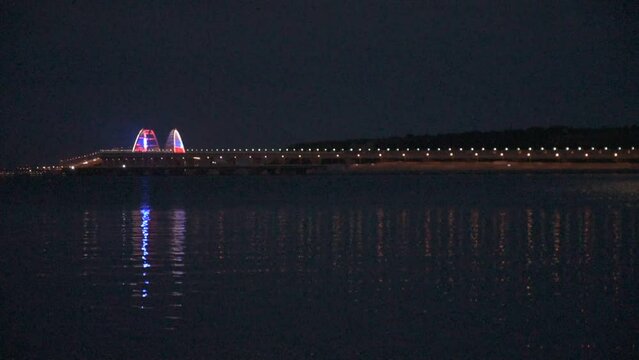 View of the Crimean bridge at night in the full moon from the embankment of the city of Kerch, Crimea, Russia.Video.HD