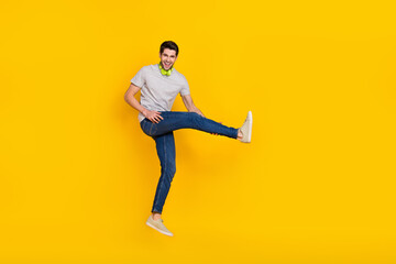 Fototapeta na wymiar Full length body size view of attractive cheerful funny guy jumping fooling listening hit isolated over bright yellow color background