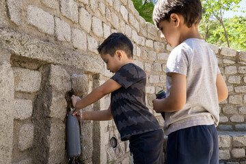Obraz na płótnie Canvas multiethnic children taking water on a font with aluminium bottles
