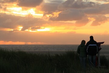 Fototapeta na wymiar people watching the sunset on the north sea