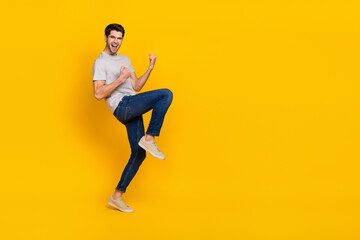 Fototapeta na wymiar Full size photo of cool brunet young guy yell wear t-shirt jeans footwear isolated on yellow background