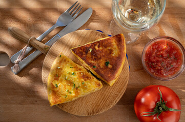 Spanish vegetarian food, portion of homemade potato omelette tortilla de patatas with onion served outdoor in morning sunlights
