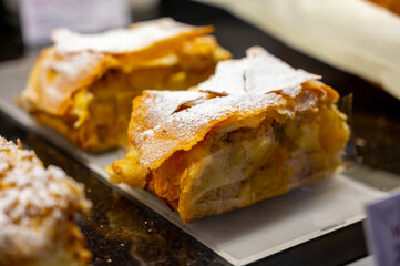 Austrian desserts, piece of apple strudel on display in traditional bakery cafe in Vienna.