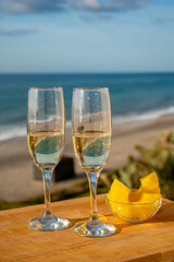 Outdoor breakfast with Spanish cava sparkling wine and pineapple with view on blue sea and sandy beach in Marbella, Costa del Sol vacation destination, Andalusia, Spain