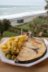 Seafood dish served in beach cafe with sea view, grilled steak from swordfish or spada served with...
