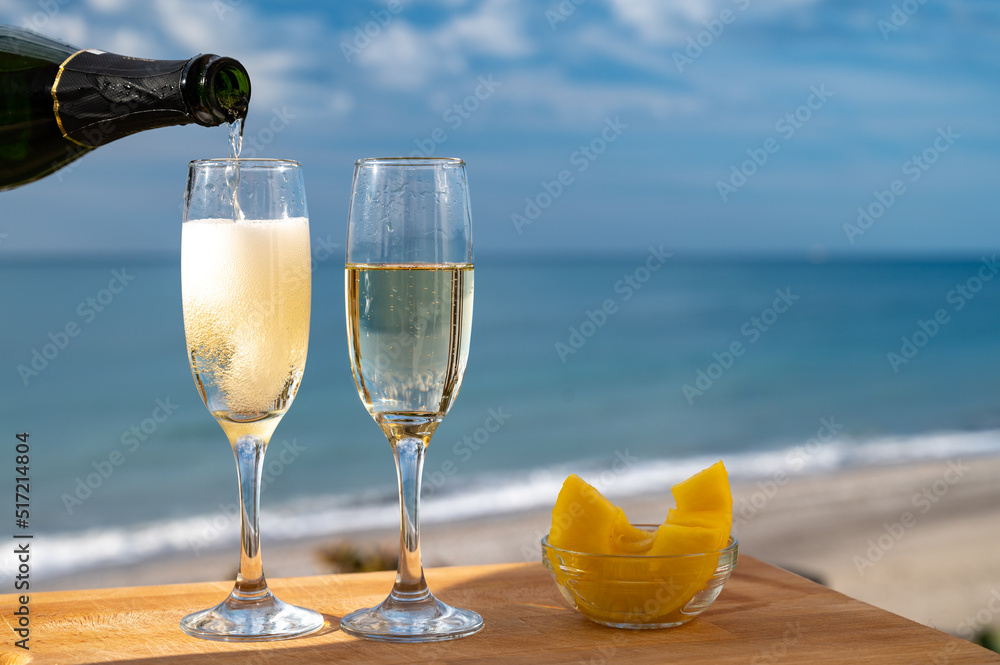 Wall mural outdoor breakfast with spanish cava sparkling wine and pineapple with view on blue sea and sandy bea