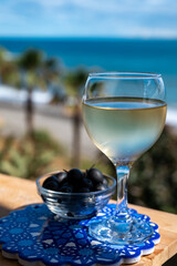 Spanish dry rueda white wine and black olives tapas served on beach terrace with view on Mediterranean sea