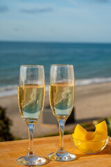 Outdoor breakfast with Spanish cava sparkling wine and pineapple with view on blue sea and sandy beach in Marbella, Costa del Sol vacation destination, Andalusia, Spain