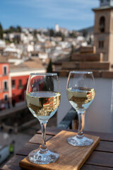 Two glasses of Spanish dry rueda white wine served on roof terrace with view on old part of Andalusian town Granada, Spain