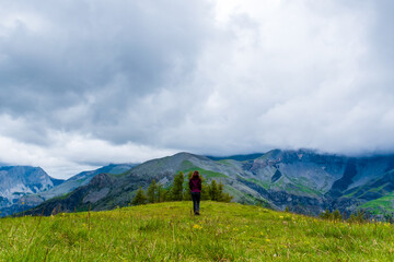 A wide angle shot of a young female hiker on a break during a hike on a cloudy summer day in the French Alps (Valberg, Alpes-Maritimes, France) © k.dei