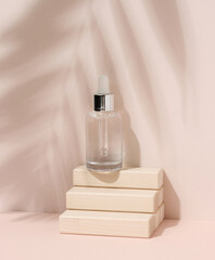 White glass bottle with a pipette on beige background. Palm leaf shadow