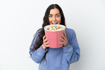 Young caucasian woman isolated on white background holding a big bucket of popcorns