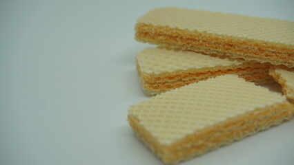 Tasty wafer sticks on white background, flat lay. Sweet food
