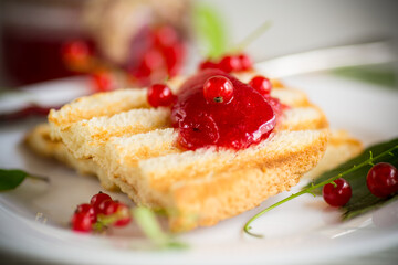 fried bread croutons for breakfast with redcurrant jam in a plate with berries