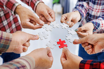 Close up Businesspeople hand holding jigsaw puzzle in a circle on the table, success and strategy concept.