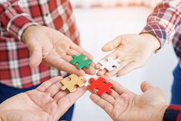 Close up Businesspeople hand holding jigsaw puzzle in a circle on the table, success and strategy concept.