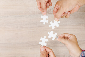 Close up Businesspeople hand holding jigsaw puzzle in a circle on the table, success and strategy concept.