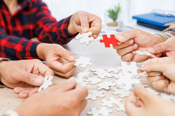 Obraz na płótnie Canvas Close up Businesspeople hand holding jigsaw and jigsaw puzzle on the table, success and strategy concept.