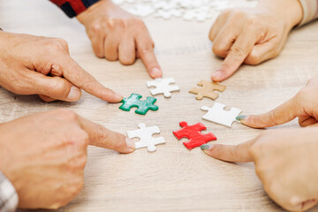 Close up Businesspeople hand holding jigsaw puzzle in a circle on the table, success and strategy concept.