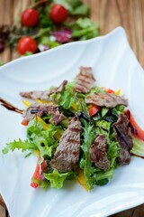 Salad with fried meat and fresh vegetables. A dish from a chef in a restaurant.