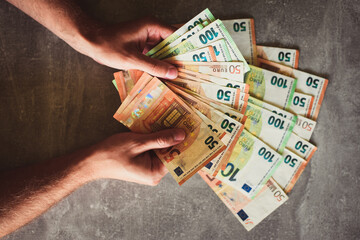 Euro banknotes in man's hand - obrazy, fototapety, plakaty