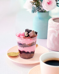 Pink and blue delicate confectionery and sweet pink dessert with a cup of americano. Mobile photo.