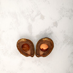 Spoiled avocado fruit, cut in half.  Brown rotten pulp. Gray background, copy space. Concept -...