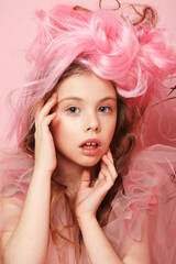 Little child girl in a pink dress, like a princess, pink hair and makeup.