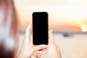 close up view of young woman holding smart phone over shoulder.
