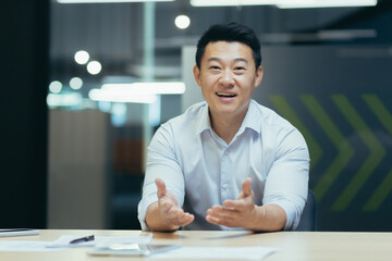Online webinar. Portrait of an active young Asian businessman. He conducts an online webinar on...