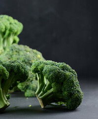 Fresh green head of broccoli on black background.